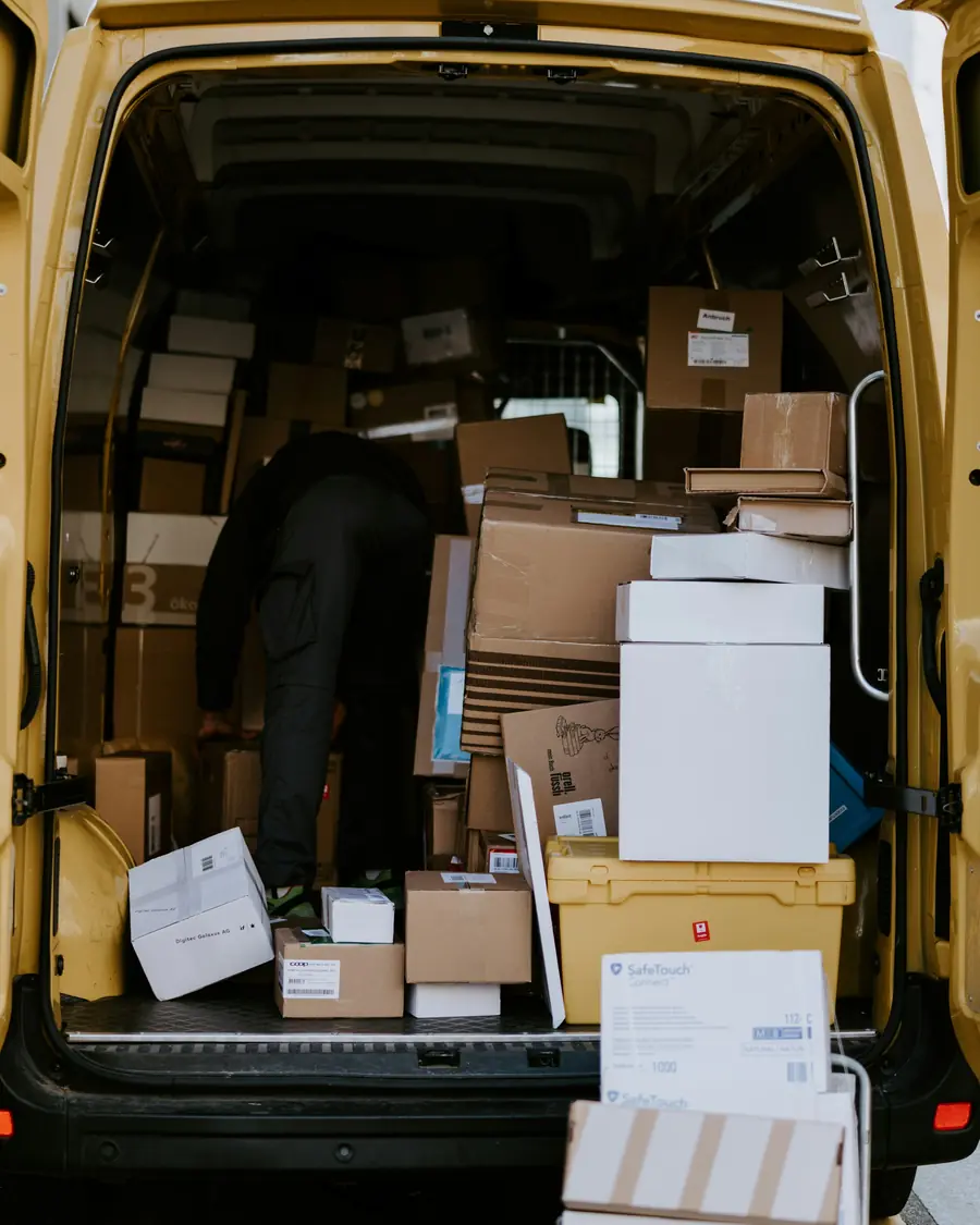 Rear of a delivery van packed with stacked parcels ready for a route